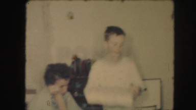 1958: siblings are seen on a table posing beside a christmas tree AMES, IOWA