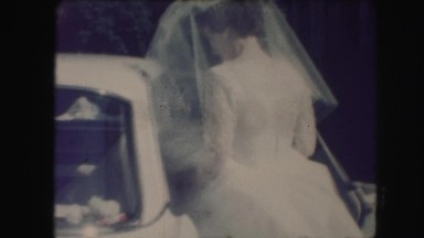 1958: newly wed bride entering bridal car in the backseat AMES, IOWA