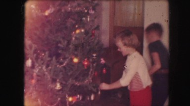 1958: a christmas tree is seen with a child opening presents AMES, IOWA