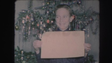 1958: a christmas tree is seen with a child opening presents AMES, IOWA