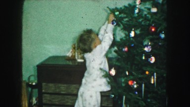 1958: a christmas tree is seen with a child opening presents AMES, IOWA