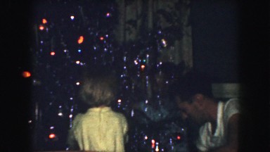 1958: a christmas tree is seen with a child opening presents AMES, IOWA