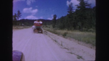 1958: orange and blue cart on an old road surrounded by mountains COLORADO
