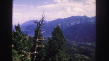 1958: a beautiful blue sky above a beautiful rugged mountain peak as seen pine