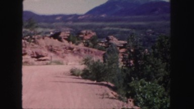 1958: couple stand upon an amazing stack of rocks under the blue sky COLORADO