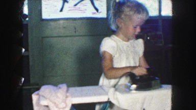 1958: little girl pretending to iron daddy's shirts AMES, IOWA