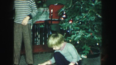 1958: a christmas tree is seen with a child opening presents AMES, IOWA