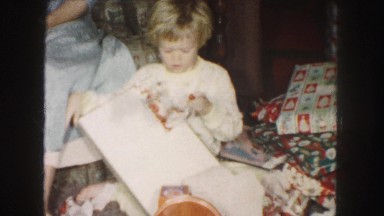 1958: a little girl in living room at christmas receive a red and white dress.