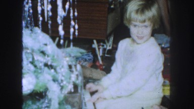 1958: christmas morning a child unwraps and plays a toy piano AMES, IOWA
