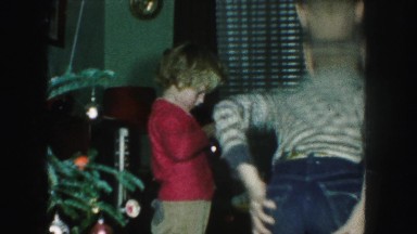 1958: siblings are seen on a table posing beside a christmas tree AMES, IOWA