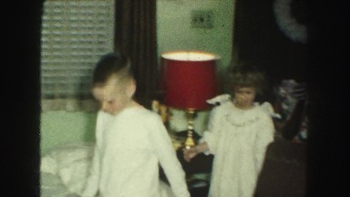 1958: kids in pajamas opening gifts from under a christmas tree AMES, IOWA