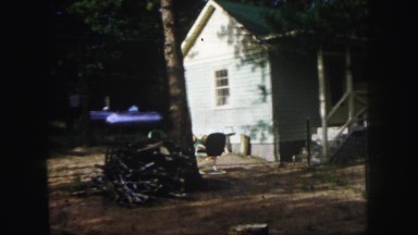 1958: a rustic unkept yard and gas tank in front of a white house COLORADO