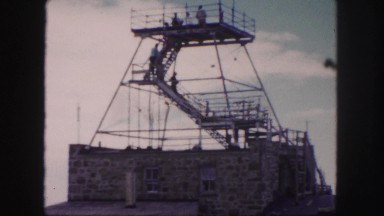 1958: people climbing down the stairs of a lookout point and a rugged landscape