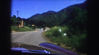 1958: a car is being driven along a country road passing a ridden horse