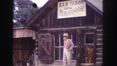 1958: a man in a costume in front of an amusement park general store COLORADO