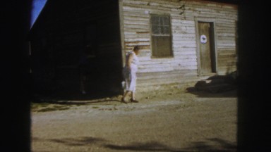1958: women outside peering through the door and window