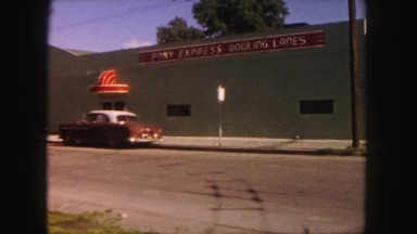1958: cars parked at curbs between street and front of individual buildings.