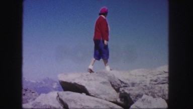 1958: an old woman standing upon a high rock under the blue sky COLORADO