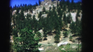 1958: a beautiful blue sky above a beautiful rugged mountain peak as seen pine