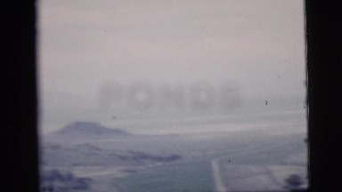 1958: wide open prairie view with scattered pines and mountains in the distance
