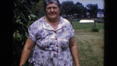 1960: old woman standing next to bush WAUCONDA, ILLINOIS