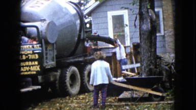 1960: workers stand beside a huge concrete mixing machine WAUCONDA, ILLINOIS