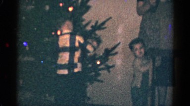 1959: Child Opening Christmas Presents Under Tree at Catskill Game Farm