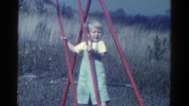 1959: child playing on a red swing set CATSKILL GAME FARM, NEW YORK