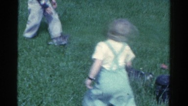 1959: kids outside in the yard playing with two cute puppies CATSKILL GAME FARM