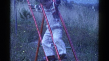1959: young boy plays happily on a swing set CATSKILL GAME FARM, NEW YORK