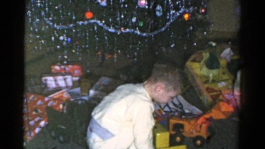 1959: opening christmas presents at home in front of christmas tree