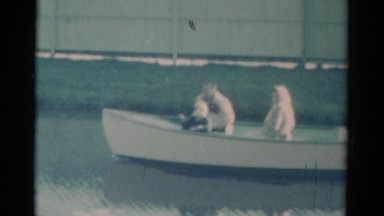 1959: man, woman and child ride in front of swan boat with operator in back.
