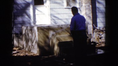 1960: man hoses off his porch WAUCONDA, ILLINOIS