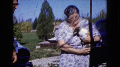 1960: woman holds her canine friend and puts on a happy face WAUCONDA, ILLINOIS