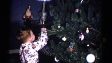 1959: a little boy is putting an ornament on a christmas tree