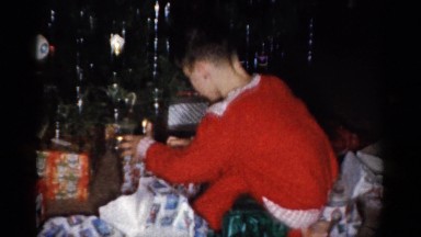1959: child unwrapping holiday presents CATSKILL GAME FARM, NEW YORK