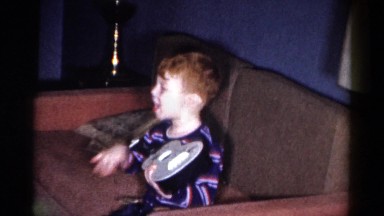 1959: child, about five, playfully strumming on a ukelele and singing CATSKILL