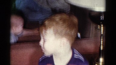 1959: baby and young child playing and talking near couch and lamp