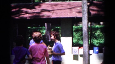 1963: a family including children and teenagers gathered outdoors in the sun