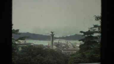 1974: cloudy day of a panoramic view of the river with a bridge and barge