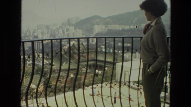 1974: woman enjoys her balcony view of city INDIA