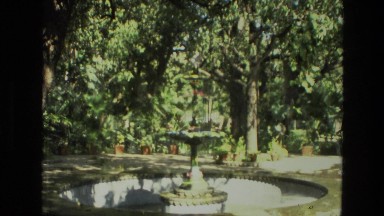 1974: a beautiful bird perched atop a large water fountain in a park INDIA
