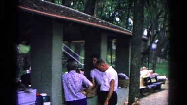 1963: family having a serious talk during bbq at a park