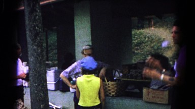 1963: women, men and children gathered outside under a covered picnic area