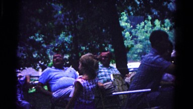 1963: various people sitting outside in the woods as a young girl walks by