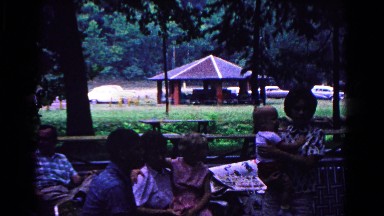 1963: family members relax at a reunion located nearby park with covered shelter