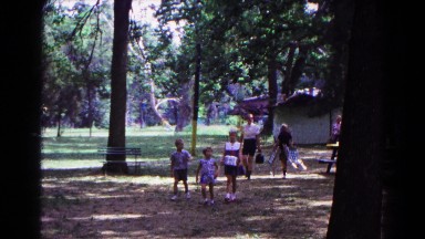 1963: a family arriving at a park with chairs, food and blankets