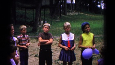 1963: children blowing bubbles and fidgeting while waiting outdoors