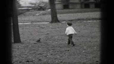 1948: Black and White Recording of a Boy Chasing a Squirrel in a Park
