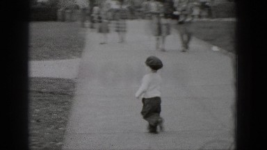 1948: cute toddler boy chasing rabbit animal down street. MIDDLETOWN